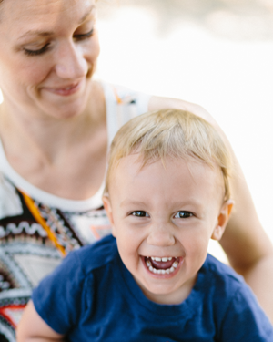 Elger Dental | Happy toddler laughing while sitting on their mother's lap
